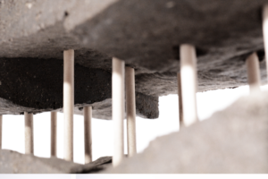 Different angles of an architectural model made of rammed earth, supported by wooden dowels.